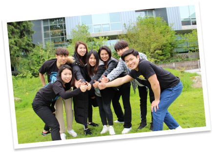 A group of smiling students give "thumbs up" sign